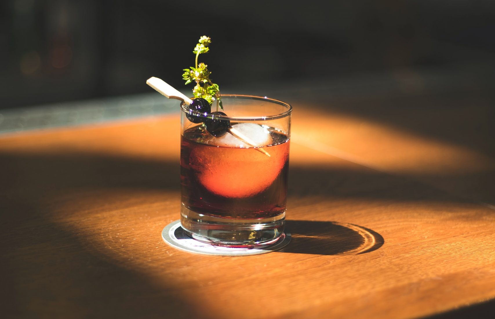 A refreshing drink garnished with a slice of fruit, elegantly placed on a rustic wooden table.